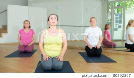Group of people exercising during yoga class 80292897