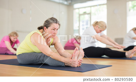 Women making yoga at gym. Paschimottanasana pose 80293580
