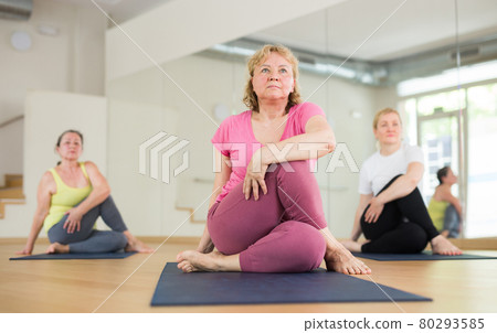 Active elderly woman practicing yoga at group Active elderly woman practicing yoga at group 80293585
