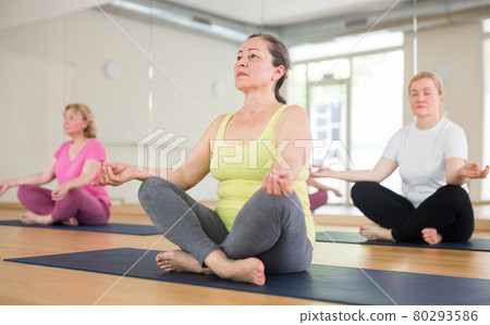 Aged women are sitting in a lotus pose Aged women are sitting in a lotus pose 80293586