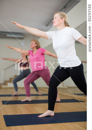 Ladies are doing warrior II pose Ladies are doing warrior II pose 80293588