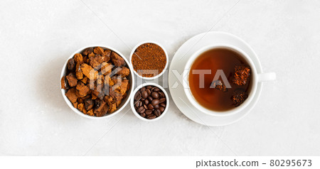 Chaga mushroom drink with coffee and chopped chaga pieces on a white background. New superfood trend. Top view, flat lay. 80295673
