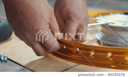 Technician man working motorcycle wheel has spokes weave up on mechanic new steel wheel 80295876