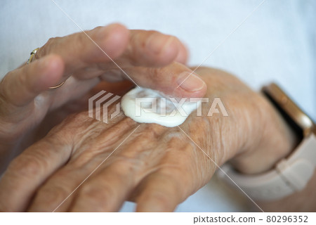 Senior women apply hand cream on her hands. Close up. Senior women apply hand cream on her hands. Close up. 80296352