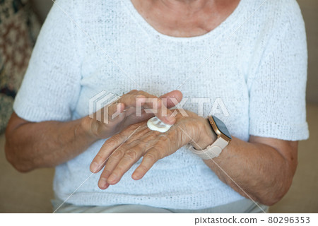 Senior women apply hand cream on her hands. Close up. Senior women apply hand cream on her hands. Close up. 80296353