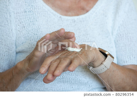 Senior women apply hand cream on her hands. Close up. Senior women apply hand cream on her hands. Close up. 80296354