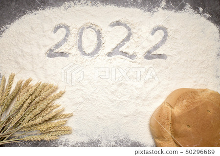 Number 2022 with ears of wheat and loaves of bread on flour. New Year and Christmas concept Number 2022 with ears of wheat and loaves of bread on flour. New Year and Christmas concept 80296689