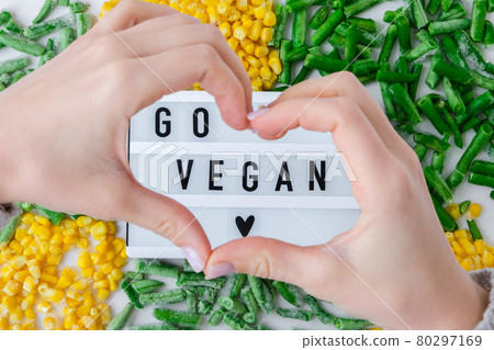 Lightbox with text GO VEGAN frozen vegetables food of yellow corn, green beans. Harvest Food preservation for winter. Lightbox with text GO VEGAN frozen vegetables food of yellow corn, green beans. Harvest Food preservation for winter. 80297169