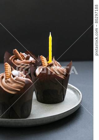 Delicious chocolate cupcakes with cream on dark background. Three chocolate muffin. Birthday cake party. Delicious chocolate cupcakes with cream on dark background. Three chocolate muffin. Birthday cake party. 80297188