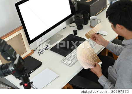 Cropped shot of graphic designer or photographer is working on color selection, colour swatches at work space. Cropped shot of graphic designer or photographer is working on color selection, colour swatches at work space. 80297373