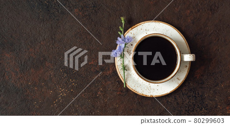 Cup with chicory drink and blue flower on dark brown background. Herbal coffee substitute. Copy space, top view, flat lay. Cup with chicory drink and blue flower on dark brown background. Herbal coffee substitute. Copy space, top view, flat lay. 80299603