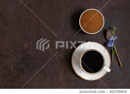 Cup with chicory coffee, chicory powder and blue flowers on a brown background. Space for text. Top view. Cup with chicory coffee, chicory powder and blue flowers on a brown background. Space for text. Top view. 80299604