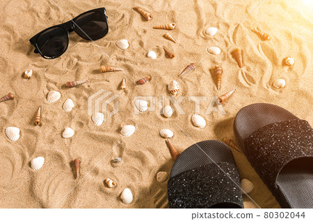 Black flip-flops and sunglass, seashell on sand. With place for your text. Top view Black flip-flops and sunglass, seashell on sand. With place for your text. Top view 80302044