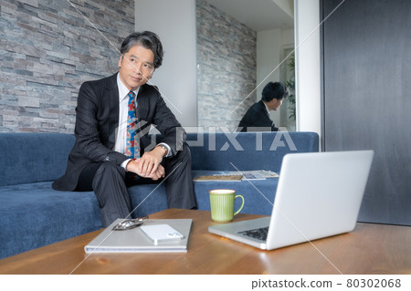 一位中年男子坐在大堂的畫像 80302068