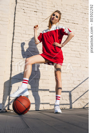 Beautiful adorable young girl in retro 90s fashion style, outfits posing on stairs, outdoors. Concept of eras comparison, beauty, fashion and youth. Beautiful adorable young girl in retro 90s fashion style, outfits posing on stairs, outdoors. Concept of eras comparison, beauty, fashion and youth. 80302292