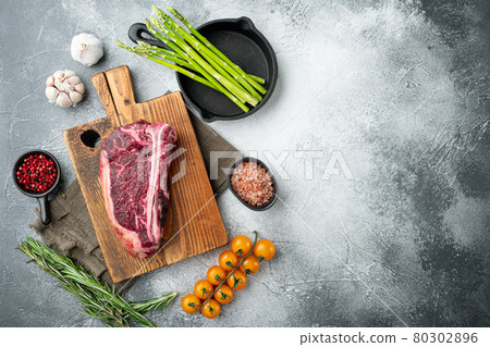 Raw fresh marbled meat black angus club steak and ingredients, on gray stone background, top view flat lay, with copy space for text 80302896