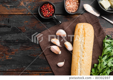 Ingredients for sandwich with butter, herbs and baguette, on old dark wooden table background, top view flat lay, with copy space for text 80302897