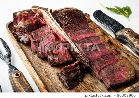 Barbecue dry aged Wagyu Porterhouse Steak sliced medium rare cooked marbled meat, on white stone background 80302906