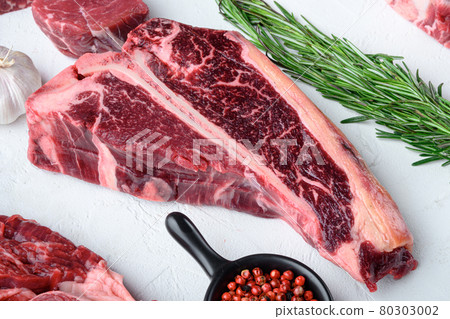 Raw fresh beef T bone steak, on white stone background Raw fresh beef T bone steak, on white stone background 80303002