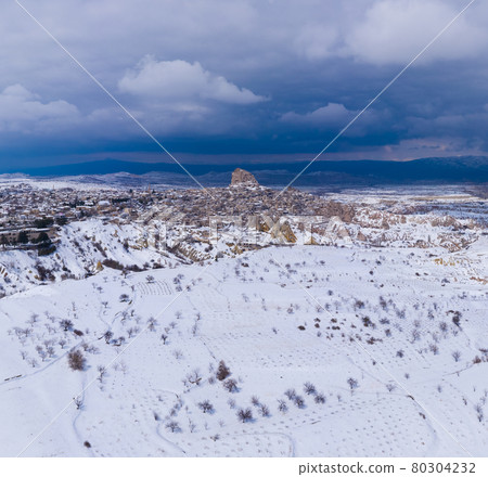 Landscape of Cappadocia and Uchisar Castle Carved in Stone in Winter. Snowy Hills. Turkey. Aerial Landscape of Cappadocia and Uchisar Castle Carved in Stone in Winter. Snowy Hills. Turkey. Aerial 80304232