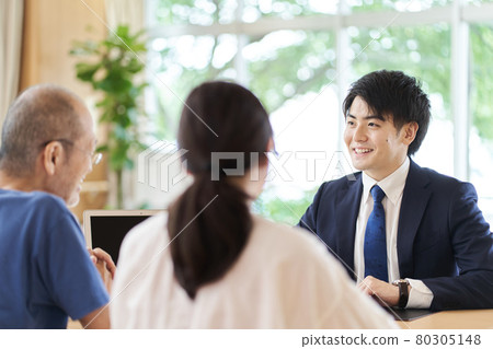 A man in the sales position who receives consultation from parents and children A man in the sales position who receives consultation from parents and children 80305148