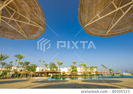 Looking up at umbrellas against sky with view pool Looking up at umbrellas against sky with view pool 80305523