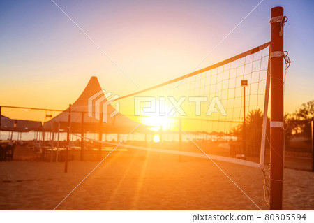 Sillhouette of a volleyball net and sunrise on the beach Sillhouette of a volleyball net and sunrise on the beach 80305594