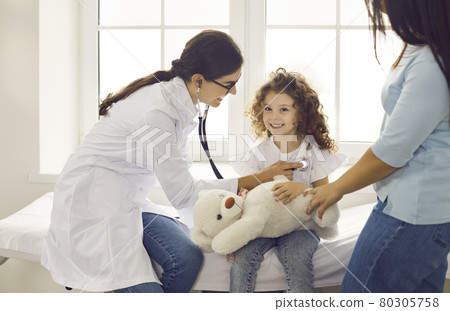 Doctor listening to young patient's breath or heartbeat during checkup at the hospital Doctor listening to young patient's breath or heartbeat during checkup at the hospital 80305758
