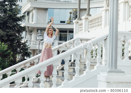 beautiful blonde woman dancing to music on the street alone beautiful blonde woman dancing to music on the street alone 80306110