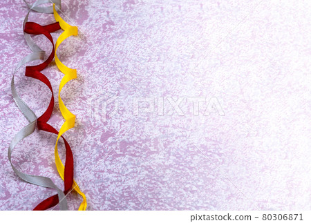 Ribbons on a pink background. Yellow and red ribbons on a light pink background. Background with ribbons. 80306871