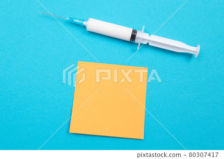 Vaccination or Revaccination Concept - A Medical Syringe on Blue Table 80307417