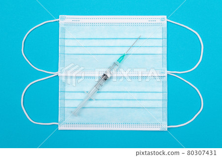 Vaccination or Revaccination Concept - A Medical Syringe on Blue Table Vaccination or Revaccination Concept - A Medical Syringe on Blue Table 80307431