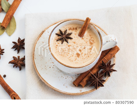 Indian Masala chai tea. Traditional Indian hot drink with milk and spices on white background closeup. Indian Masala chai tea. Traditional Indian hot drink with milk and spices on white background closeup. 80307590