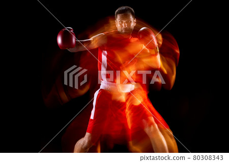 Portrait of professional male boxer in motion, action on black studio background in mixed lights. Front view Portrait of professional male boxer in motion, action on black studio background in mixed lights. Front view 80308343