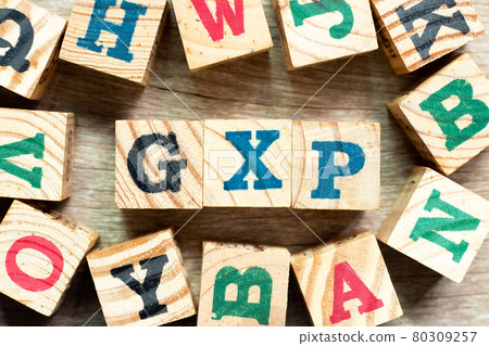 Alphabet letter block in word GXP with another on wood background 80309257