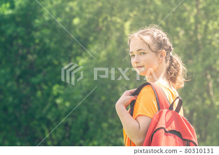 teenager girl in a bright t-shirt with backpack walks in nature teenager girl in a bright t-shirt with backpack walks in nature 80310131