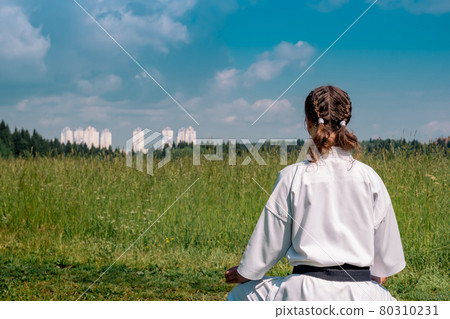 teenage girl karateka before starting training outdoor enters the mokuso meditative state in the seiza pose teenage girl karateka before starting training outdoor enters the mokuso meditative state in the seiza pose 80310231