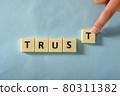 Man hand complete word Trust on plastic block 80311382
