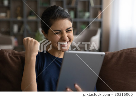 Excited Indian woman triumph with good news on cell Excited Indian woman triumph with good news on cell 80316000