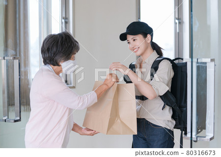 Senior woman receiving a delivery order Senior woman receiving a delivery order 80316673