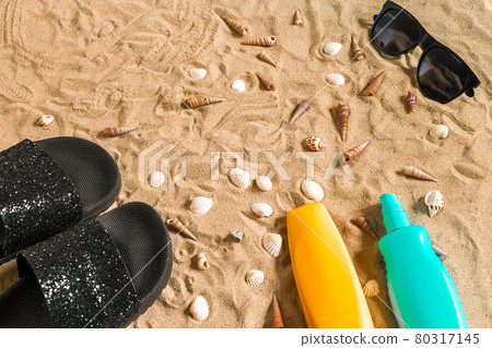 Black flip-flops and sunglass, seashell on sand. With place for your text. Top view 80317145