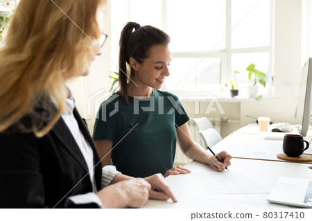 Mature business teacher supervising happy student writing notes Mature business teacher supervising happy student writing notes 80317410