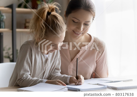 Helping young mom engaged in learning activity with preteen daughter 80317638