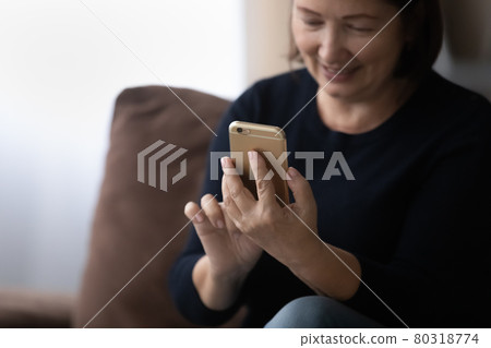 Happy older 60s woman using telehealth app on mobile phone 80318774