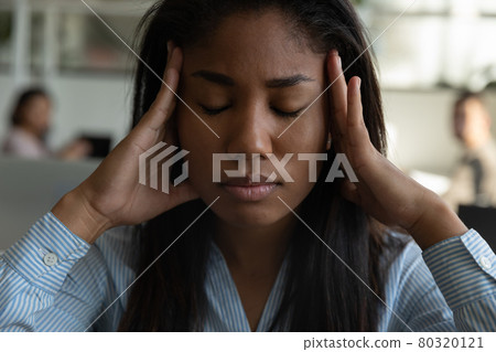 Stressed tired mixed race black office employee suffering from headache 80320121