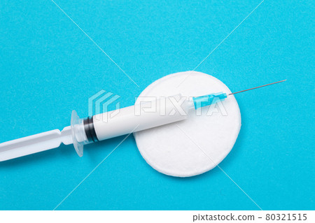 Vaccination or Revaccination Concept - A Medical Syringe on Blue Table 80321515