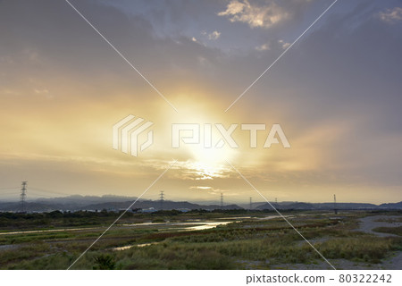 光光河床上長長的綠草，天上的太陽升起，美麗的色彩，煙霞和大地的美麗光芒。 80322242