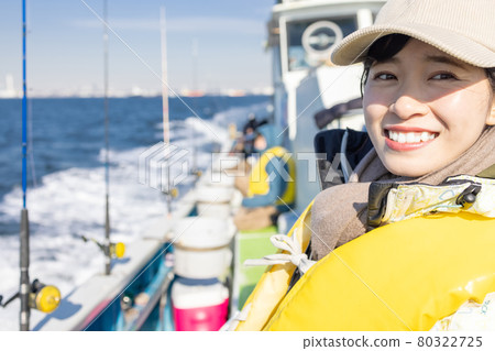 Young woman enjoying sea fishing Young woman enjoying sea fishing 80322725