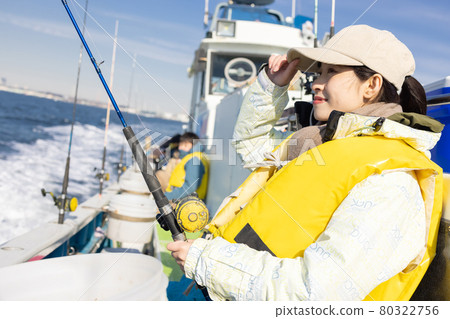 Young woman enjoying sea fishing Young woman enjoying sea fishing 80322756