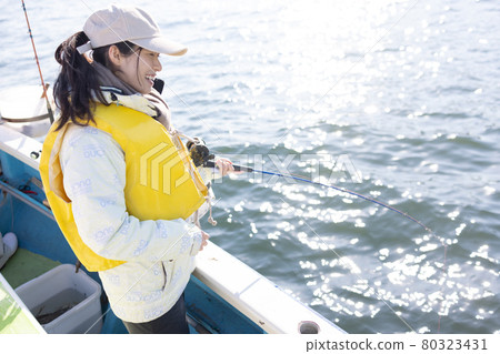 Young woman enjoying sea fishing Young woman enjoying sea fishing 80323431